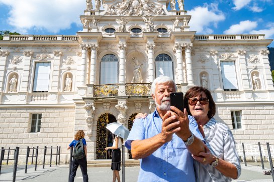man and woman taking selfie in front of Castle Linderhof